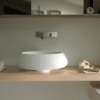 Bjhon 2 Waschbecken von Agape, Design Angelo Mangiarotti. Weißes Aufsatzwaschbecken auf Holzplatte mit Wandarmatur. Verfügbar in massivem Marmorblock, hochwertigem Cristalplant® oder Cemento.