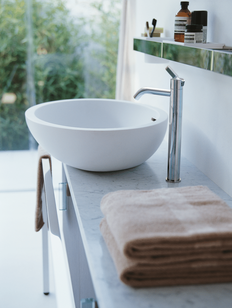 Agape Spoon XL Aufsatzwaschbecken, Detailansicht mit eleganter Chrom-Armatur auf einer Marmorplatte, definierend Luxus und Stil neu. Dieses Aufsatzwaschbecken ist verfügbar in weißem Cristalplant® biobased.