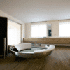 Freistehende runde Badewanne Ufo von Agape aus glänzendem Edelstahl mit weißer Cristalplant Rückstütze, Design Benedini Associati, in einem luxuriösen Badezimmer mit Holzfußboden.