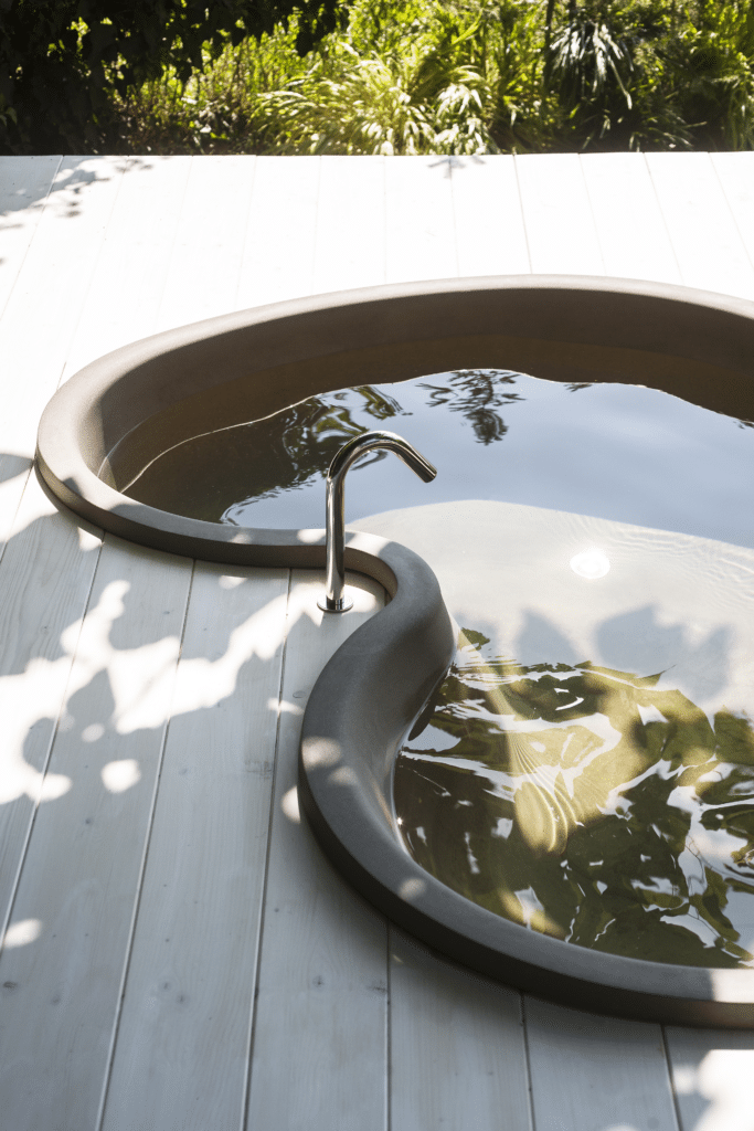 DR Badewanne von Agape, Design Studio MK27, Outdoor-Variante aus dunklem Cemento® auf einer Holzterrasse
